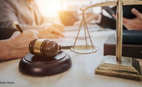 Betriebsausgabenabzug und Rückstellung des Insolvenzschuldners für die Vergütung des Insolvenzverwalters Schreibtisch mit Holzhammer und Waage der Gerechtigkeit