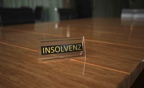 Ausgleichszahlungen nach § 35 Abs. 2, § 295 Abs. 2 der Insolvenzordnung sind keine Betriebsausgaben Ein Schild mit der Aufschrift "INSOLVENZ" auf einem Holztisch in einem Konferenzraum.