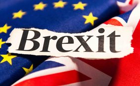 Zur weiteren Anwendung des europäischen Koordinierungsrechts auf Kindergeldfälle nach dem Brexit Das Bild zeigt das Wort „Brexit“ auf einem zerrissenen Papier über den Flaggen der EU und des Vereinigten Königreichs.